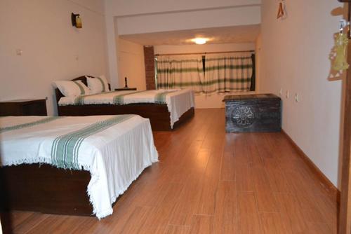 a room with two beds and a wooden floor at Panoramic View Hotel in Lalībela