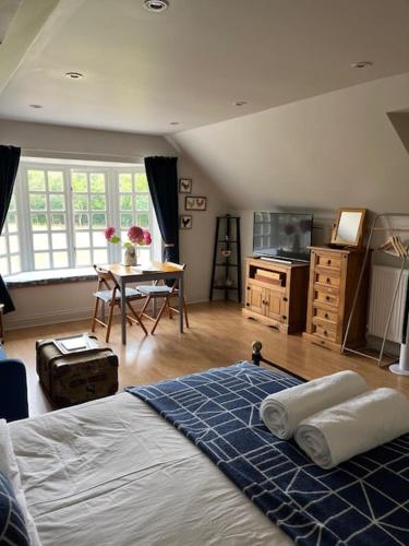 a bedroom with a bed and a kitchen with a table at The Bird Loft Studio in Horsted Keynes