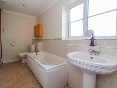 a bathroom with a sink and a tub and a toilet at Thorntons House in Northallerton