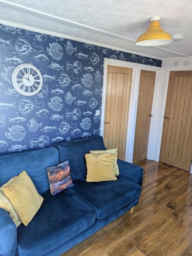 a blue couch in a living room with a wall at Savannah-by-the-sea in Bridlington