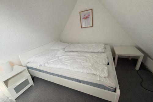a small bedroom with a bed and a table at FeWo Heaven in Winterberg