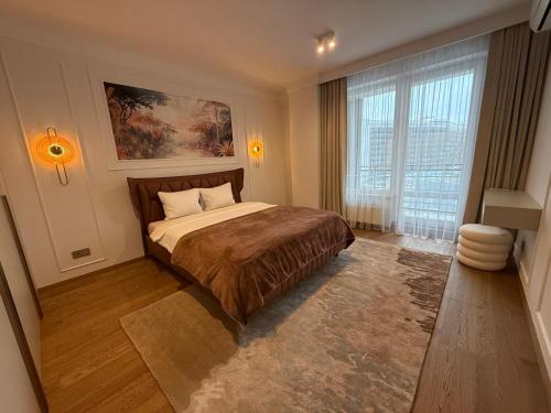 a bedroom with a bed and a large window at Luxury Oasis in the Heart of the City in Druskininkai