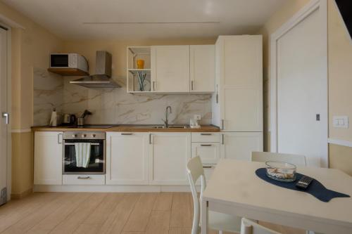a kitchen with white cabinets and a white table and a table and a tableablish at Sinarca Elysium Apartment in Termoli