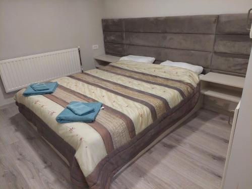 a bedroom with a bed with two blue towels on it at Srna apartmani in Čačak