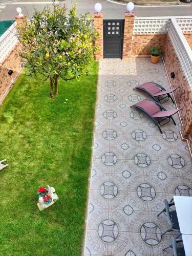 a garden with a table and chairs and a tree at APARTAMENTO COSTA CANTABRIA in Cuchia