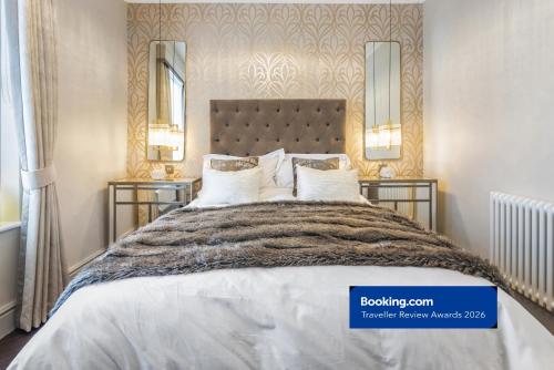a bedroom with a large bed with two mirrors at Luxury 1-Bed Apartment in sought after prime London location in London