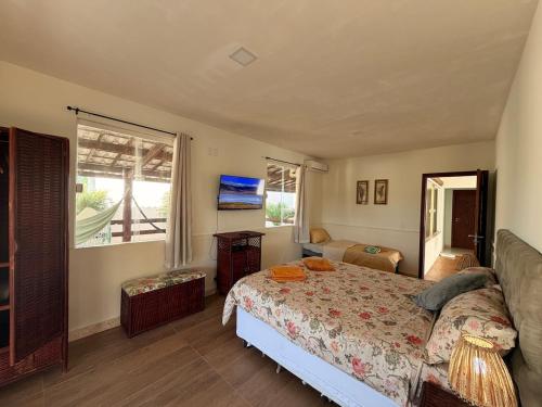 a bedroom with a bed and a large window at Villa Amarela in Itacimirim