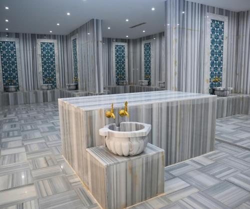 a bathroom with a tub with two faucets at Anbar International Hotel in Kumaysh