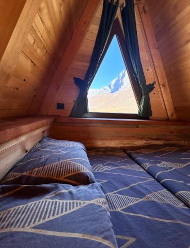 a bed in a room with a window at Etno Cottages Komarnica Authentic Peaceful Mountain Getaway in Šavnik
