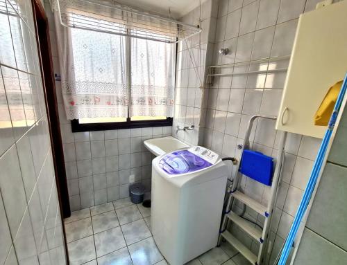 a small bathroom with a washing machine in it at Aconchego e estilo, apto 2 quartos, próximo a USP in São Carlos