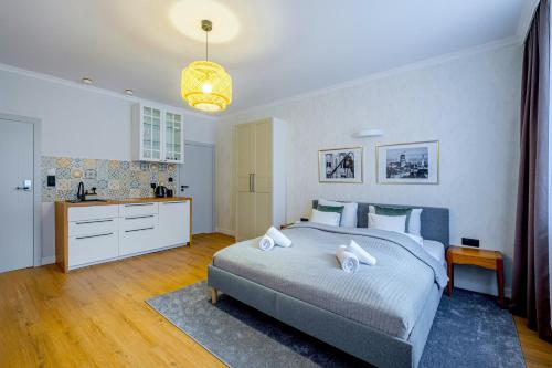 a bedroom with a large bed and a kitchen at Balans Studio Old Town I in Gdańsk