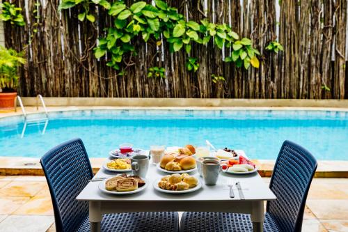 a table with food on it next to a pool at El Aram Beach Boa Viagem in Recife