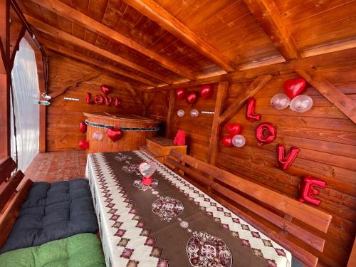 a room with a bed and red hearts on the wall at Cabana Paltini in Costeşti