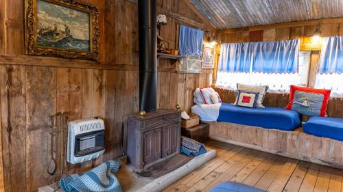 a room with a woodburning stove and two beds at Moon River Ranch in Satin