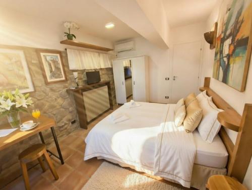 a bedroom with a large white bed and a table at Villa Gallorosso in Settignano