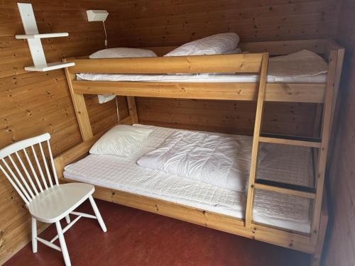 a room with two bunk beds and a chair at Skutstuga 6 - Gruvbacken Huså in Järpen