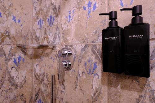 a bathroom with two shampoo bottles on a wall at La Maraviglia in Foligno