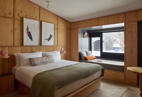 a bedroom with a large bed and a window at Balnea Hôtel - Anciennement Beatnik Hôtel in Bromont