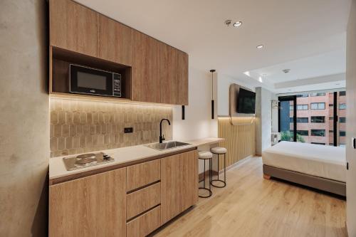 a kitchen with a sink and a bed in a room at Lomm By Somos The Group in Medellín