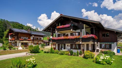 a house with flowers on the balconies of it at Gästehäuser Schwemmbauer in Reit im Winkl