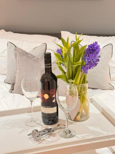 a bottle of wine and two glasses on a table at Modern, City Centre, Studio Apartment with FREE WIFI, GYM ACCESS, NETFLIX - West One in Sheffield