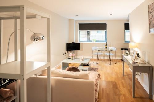 a living room with a couch and a table at Modern, City Centre, Studio Apartment with FREE WIFI, GYM ACCESS, NETFLIX - West One in Sheffield
