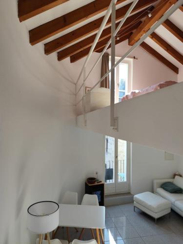 a living room with white walls and wooden ceilings at Piccolo gioiello rustico in Losone