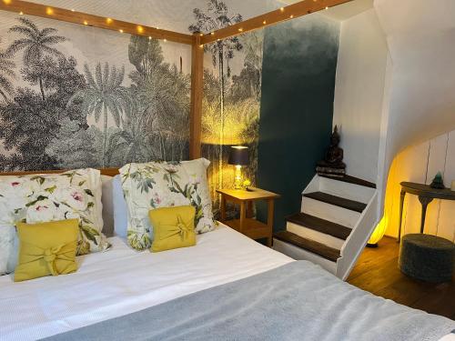 a bedroom with a bed with white sheets and yellow pillows at Church View a first floor apartment in the heart of historic Topsham in Topsham