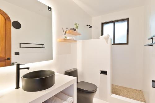 a bathroom with a sink and a toilet at Serena Nosara Beach Retreat in Nosara