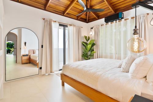 a bedroom with a large bed and a mirror at Serena Nosara Beach Retreat in Nosara