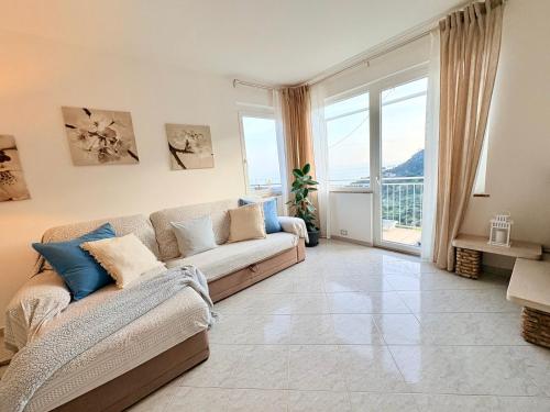 a living room with a couch and a large window at Sunrise apartament in Monterosso al Mare