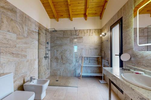 a bathroom with a toilet and a sink and a tub at Villa Cora - Traumvilla mit privatem Tennisplatz & beheiztem Pool in Triquivijate