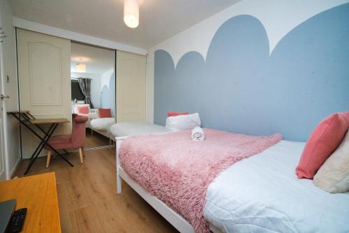 a bedroom with two beds and a desk with a desk at Home close to city center home in Milton Keynes