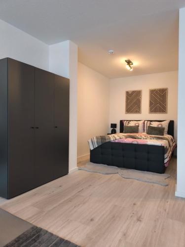 a bedroom with a bed and a black cabinet at Ferienwohnung Evelina in Bad Neuenahr-Ahrweiler
