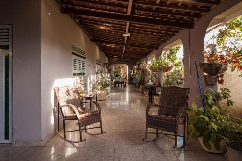 a hallway with chairs and tables and plants in a building at Casa com Varanda, Quintal e Churrasqueira em Bonito PE in Bonito
