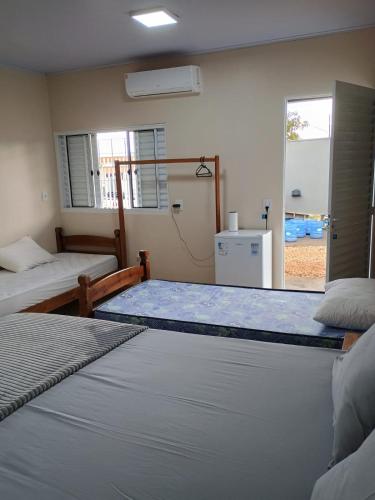 a bedroom with two beds and a window at Pousada Zero Três - 03 in Chapada dos Guimarães
