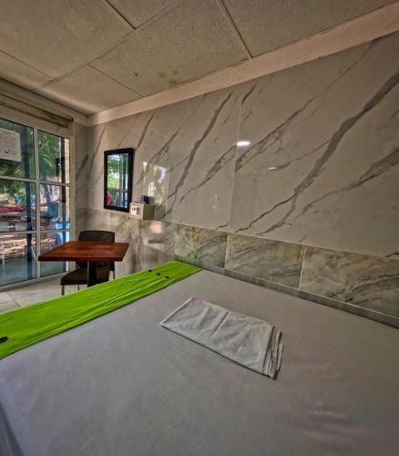 a room with a table and a marble wall at Hostal Bahia Bocachica in Cartagena de Indias