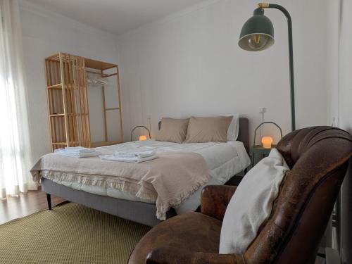 a bedroom with a bed and a chair in it at Beach Avenue Suite in Apúlia