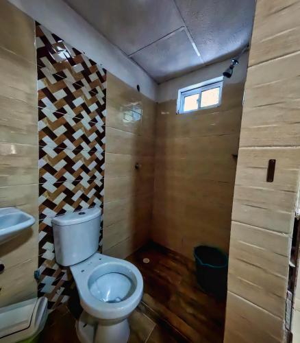 a bathroom with a toilet and a window at Hostal Bahia Bocachica in Cartagena de Indias