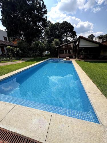 a large blue swimming pool in front of a house at Hotel las Caballerizas in Valle de Bravo