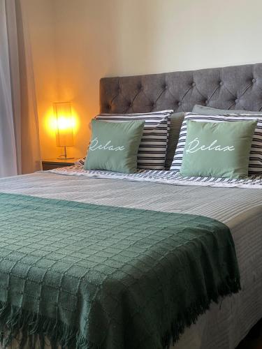 a bedroom with a large bed with two pillows at Rosario SJ Loft Studio in Rosario