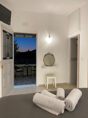 a room with a bed with a mirror and a table at LEIVADAROS apartments in Perissa