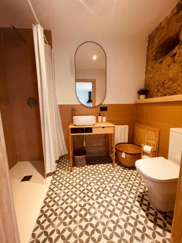 a bathroom with a sink and a toilet and a mirror at Alojamiento Rural Montseny in Breda