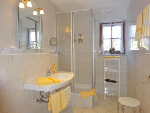 a white bathroom with a shower and a sink at Ferienwohnungen Auhaus in Bad Reichenhall