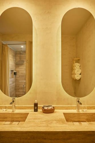 a bathroom with two sinks and a large mirror at Howard Johnson Alcántara Boutique Hotel Chacras de Coria, Mendoza in Chacras de Coria
