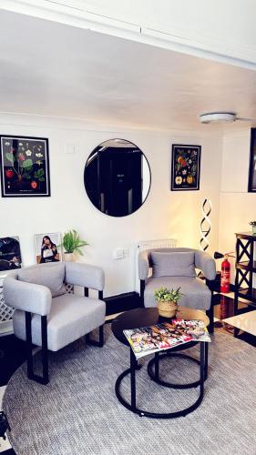 a living room with two chairs and a table at Amsterdam Hotel in London