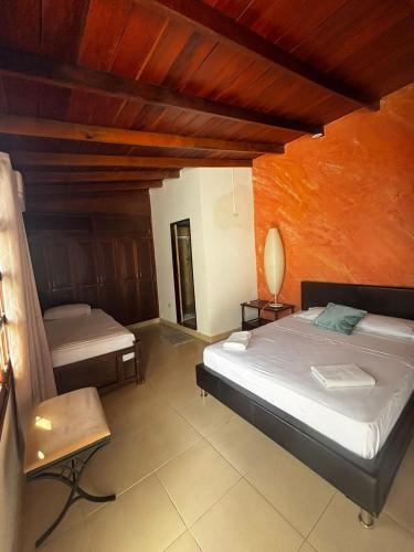 a bedroom with a bed and a chair in it at Hotel La Palma Centro Histórico in Santa Marta