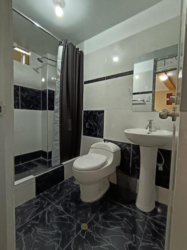 a bathroom with a toilet and a sink at Casa del Virrey Hospedaje in Jauja