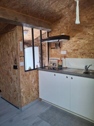 a kitchen with white cabinets and a window at Chez Marie in Le Pallet