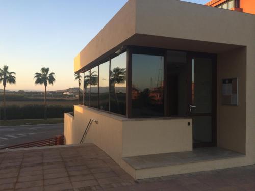 a building with windows with palm trees in the background at Ribera del Marlin - Sotogrande in Sotogrande
